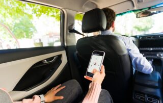 Rideshare passenger using a mobile app in the back seat, illustrating coverage questions when the Uber million-dollar insurance policy may not apply in a Scranton accident.