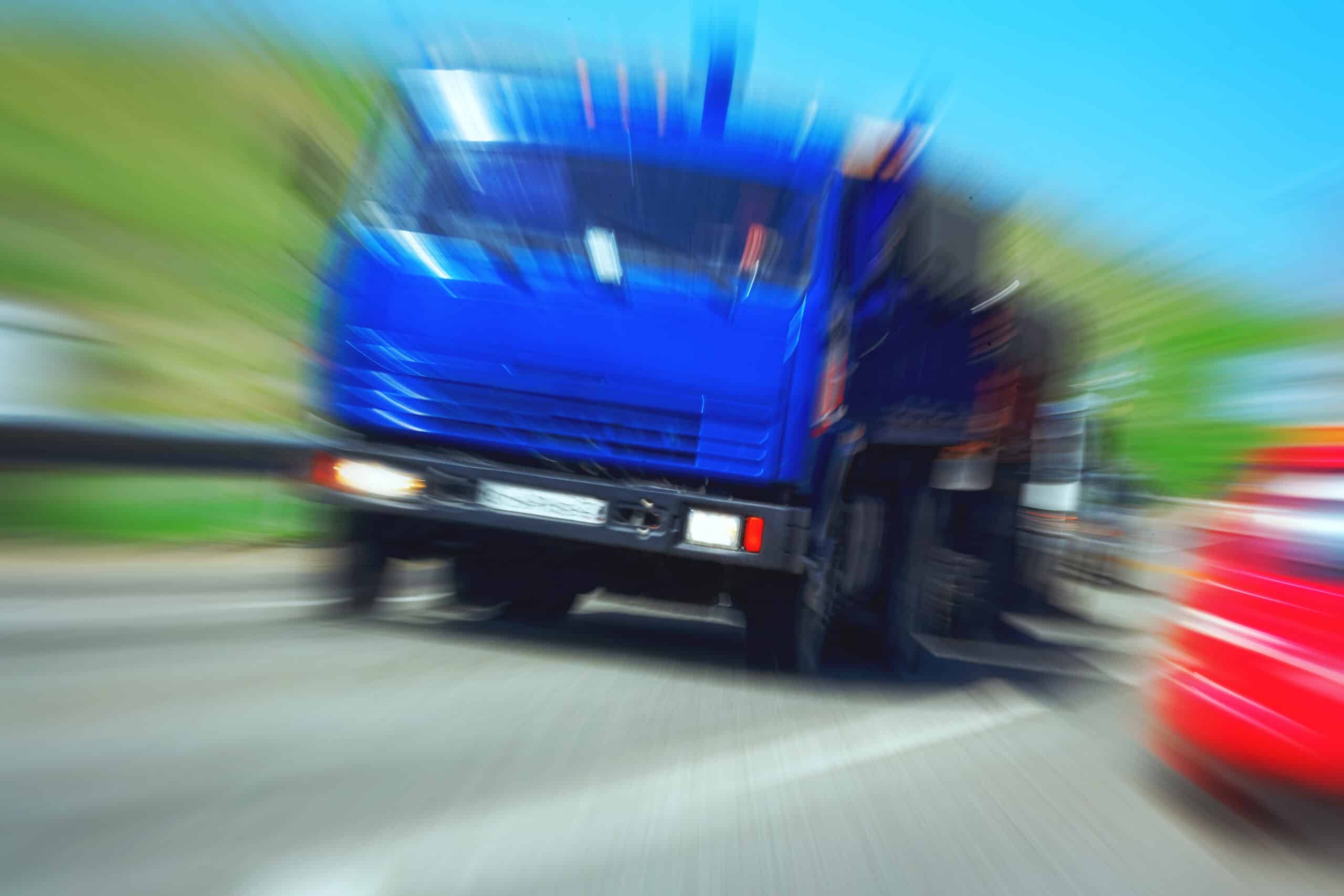 A blue semi-truck in motion with high speed blur on a highway, illustrating the danger of interstate truck accidents and PA full tort exceptions.