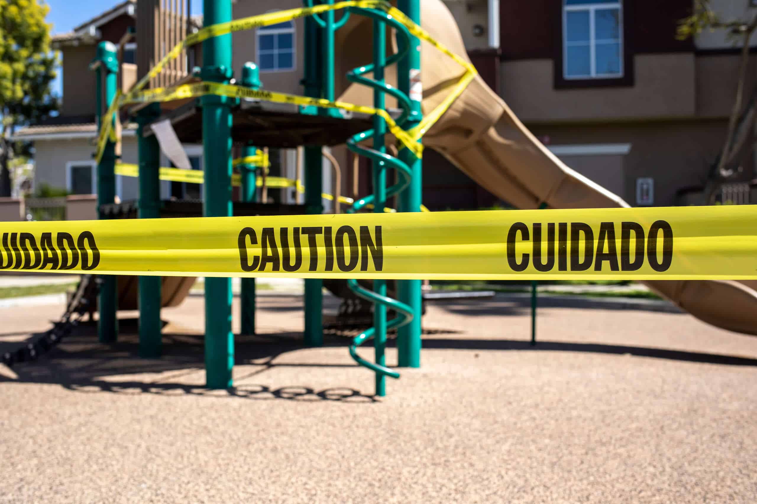 A Scranton playground area blocked off by yellow "Caution" and "Cuidado" tape, representing the hazardous property conditions handled by our premises liability lawyers.