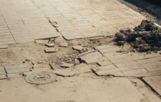 A severely damaged and crumbled sidewalk with loose concrete debris in Scranton, representing the hazardous conditions that lead to property owner liability claims.