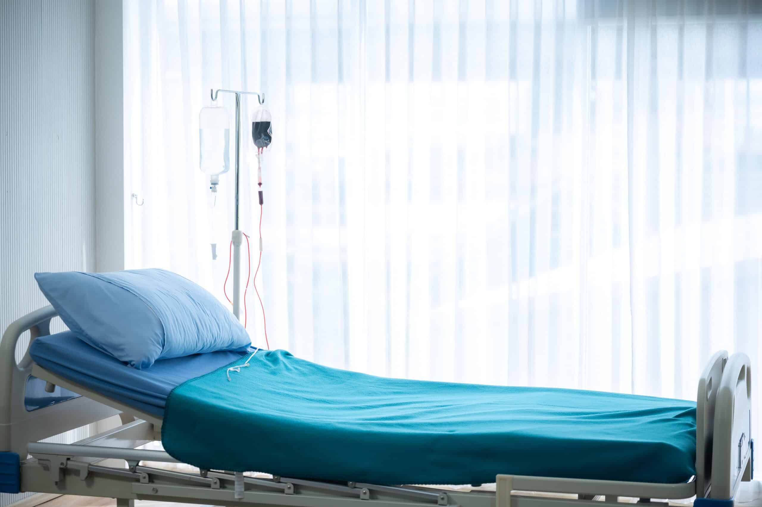 An empty hospital bed next to an IV stand in a brightly lit room, symbolizing the aftermath of a fatal accident and the legal support provided by The Slocum Firm in Scranton.