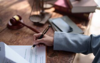 A close-up of a person signing legal estate documents in Scranton, representing the personal representative's role in filing a Pennsylvania wrongful death lawsuit.