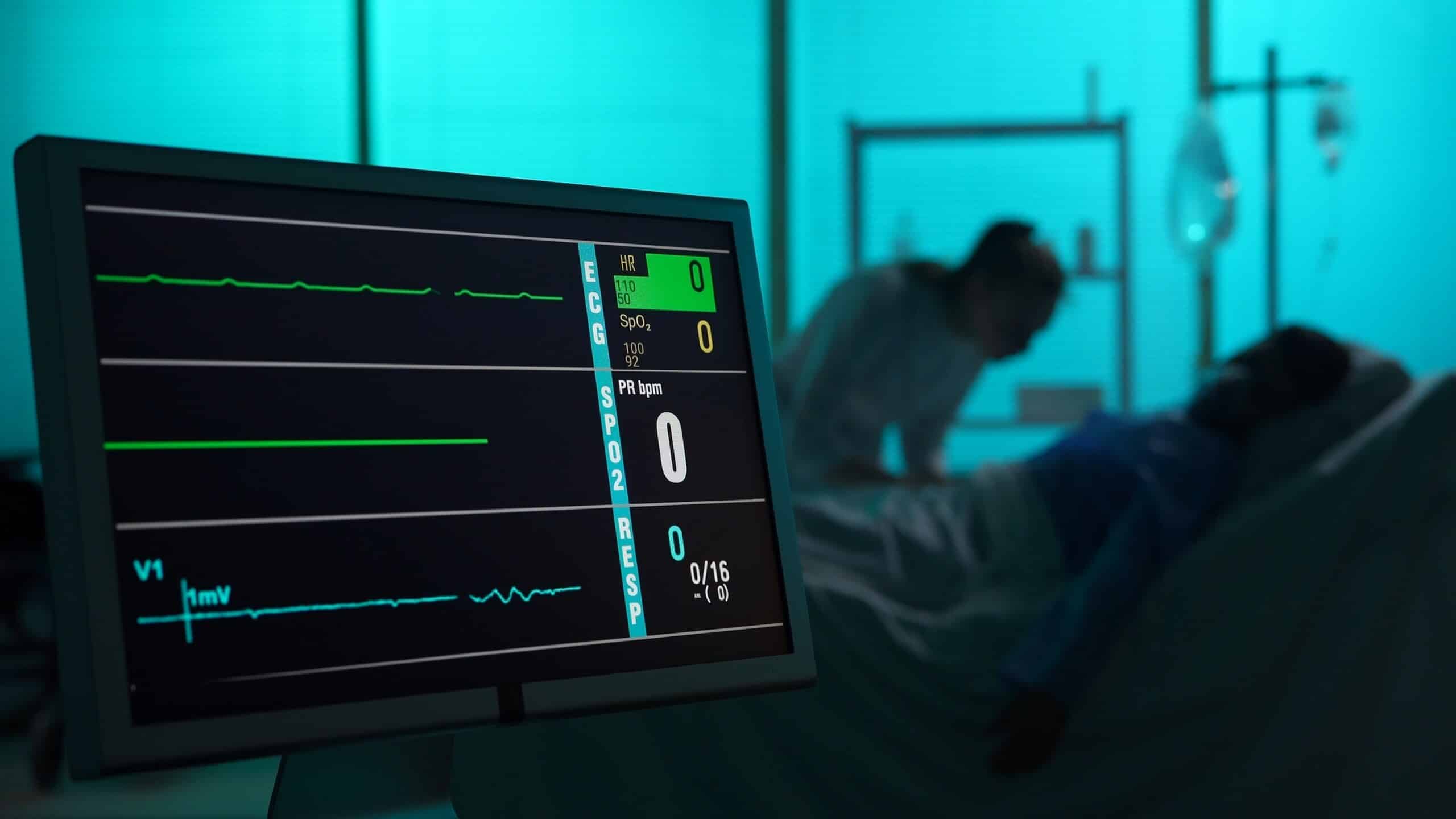 A medical monitor showing flatlined vital signs in a dimmed hospital room, illustrating the tragic loss that leads to a Scranton wrongful death claim.