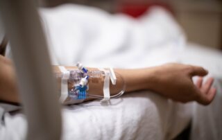 A close-up of an IV line in a patient's arm, illustrating the medical suffering considered in Scranton survival actions vs. wrongful death claims.