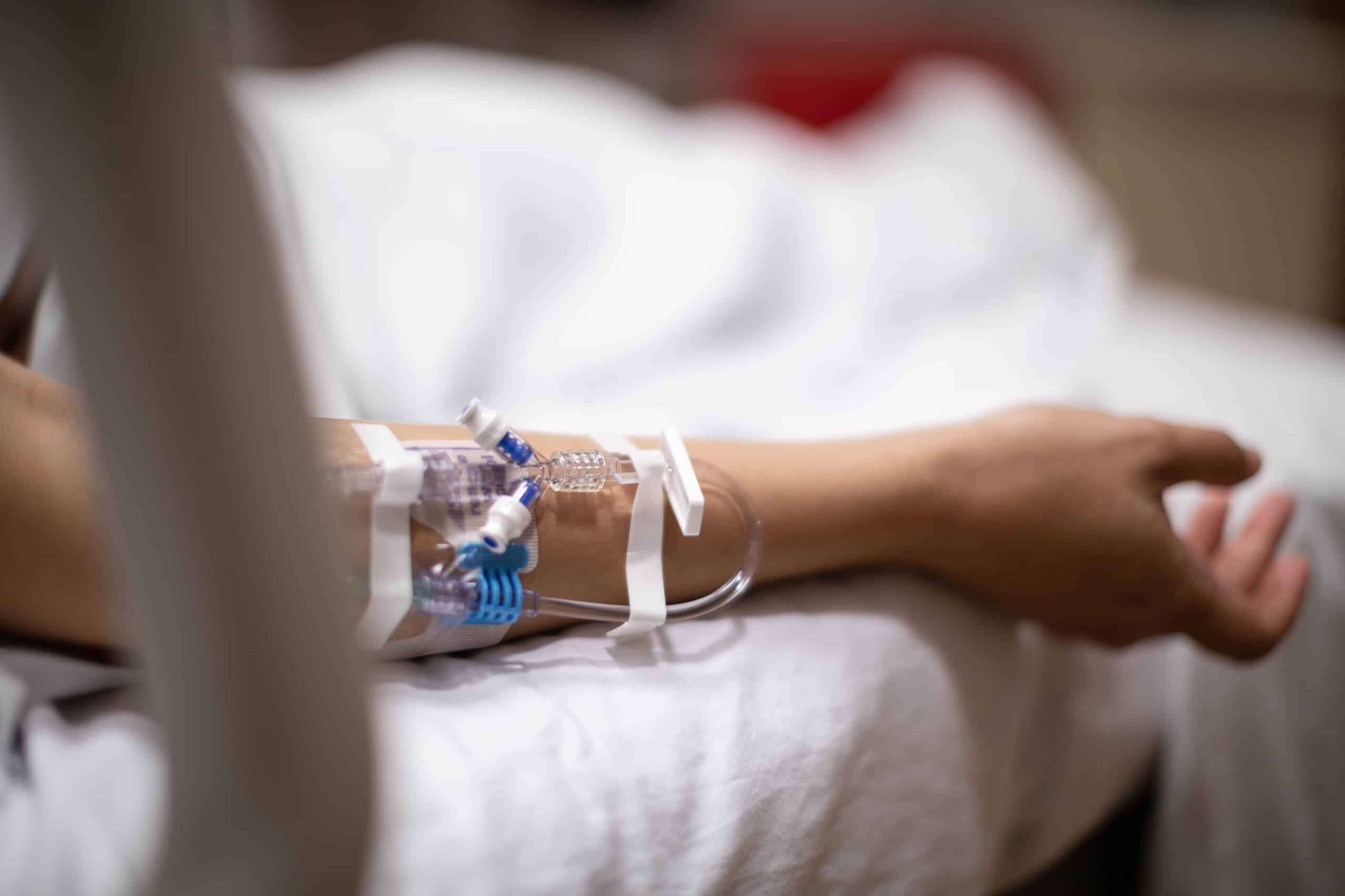 A close-up of an IV line in a patient's arm, illustrating the medical suffering considered in Scranton survival actions vs. wrongful death claims.