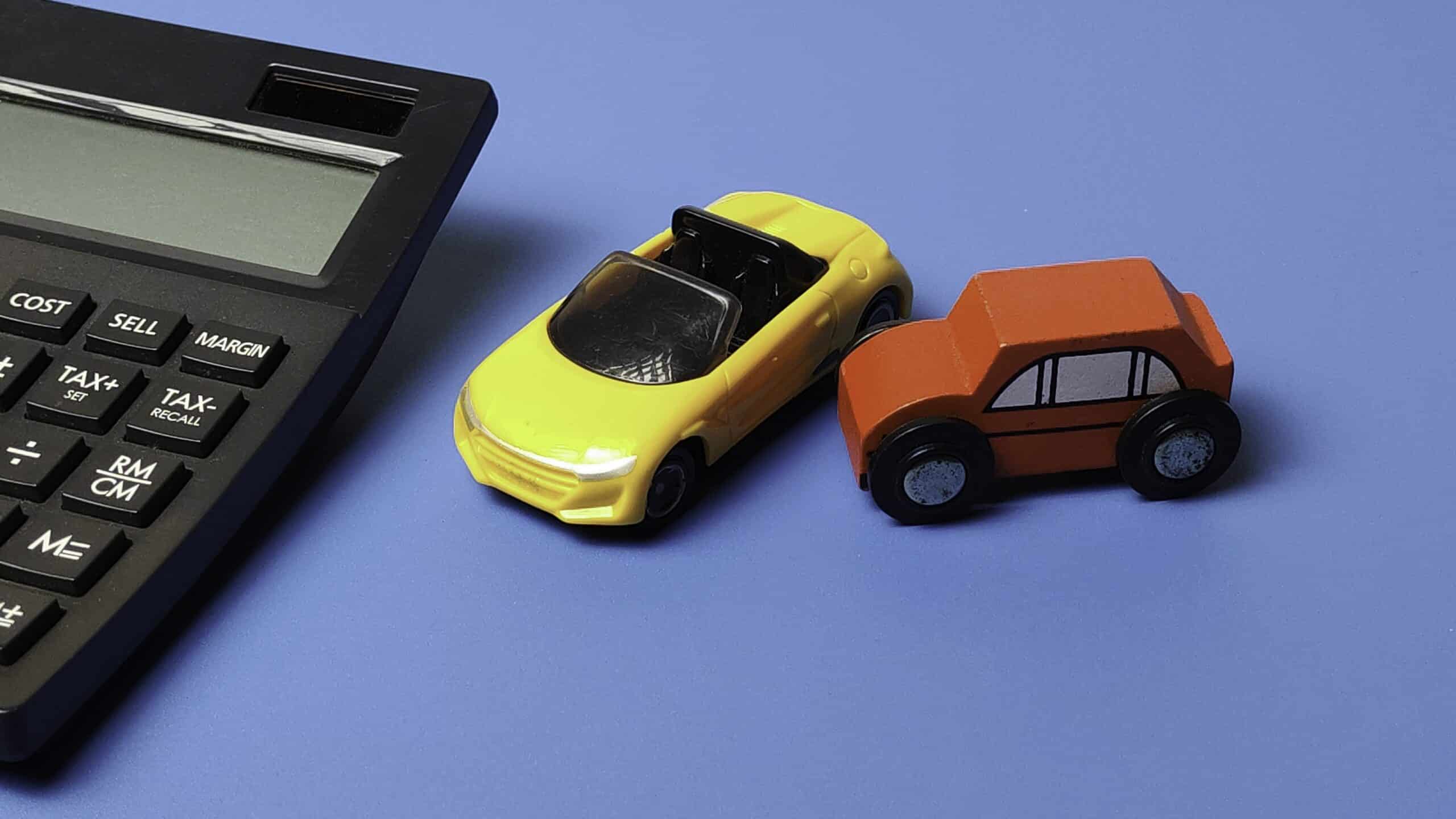 Toy cars collision next to calculator - Pennsylvania Hit and Run Accident Lawyers