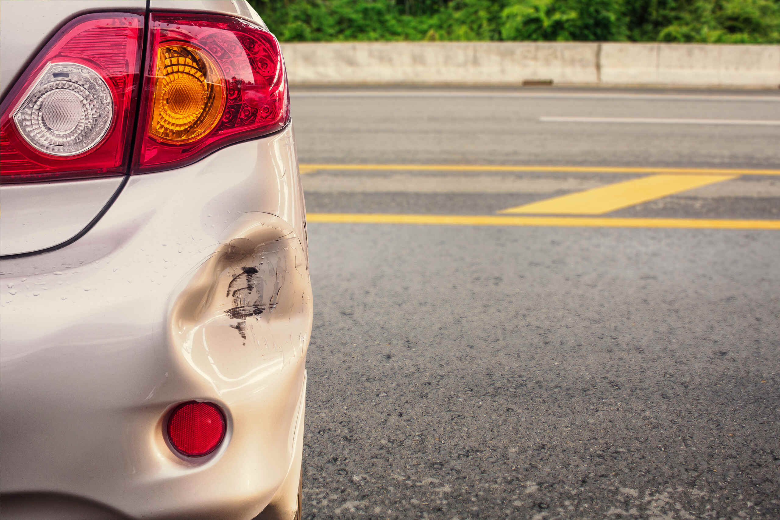 A silver car with a severely dented rear bumper shows vehicle damage evaluated by Philadelphia Hit and Run Accident Lawyers.