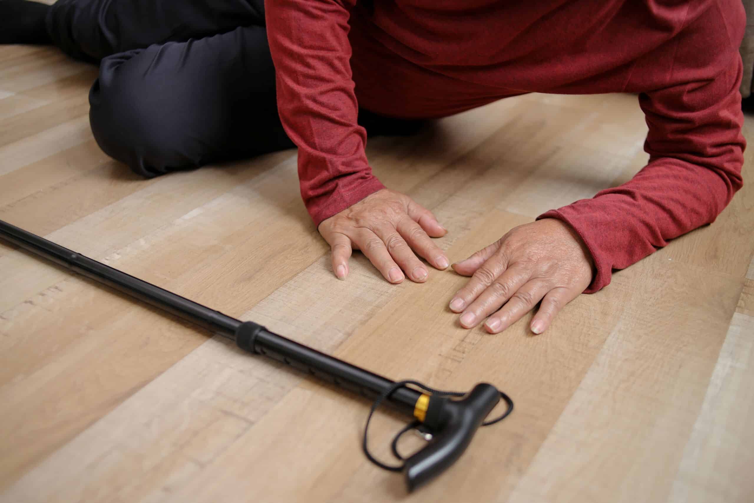 An elderly person fallen on the floor near a walking cane shows a slip and fall injury represented by Allentown personal injury lawyers.