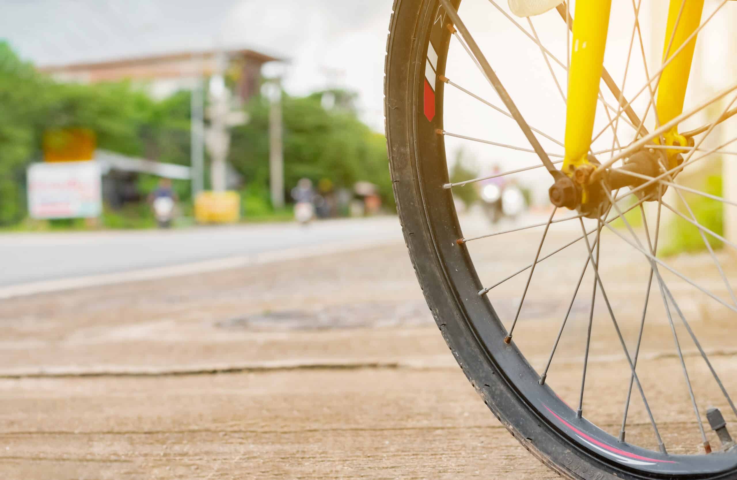 Close up of a bicycle wheel on a city street representing legal claims handled by Philadelphia bicycle accident lawyers.
