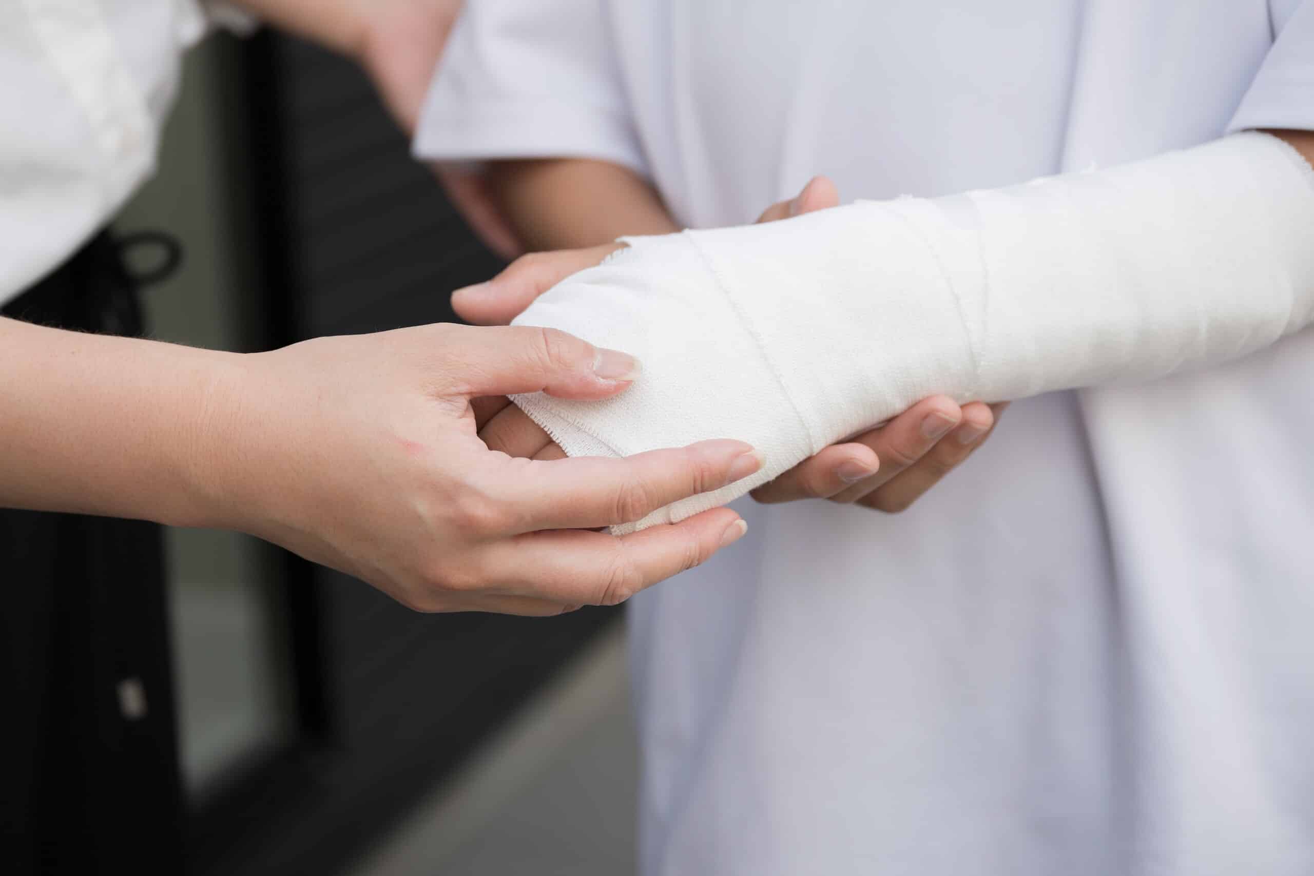 Medical provider examining a patient with a bandaged arm assisted by Pennsylvania bicycle accident lawyers.