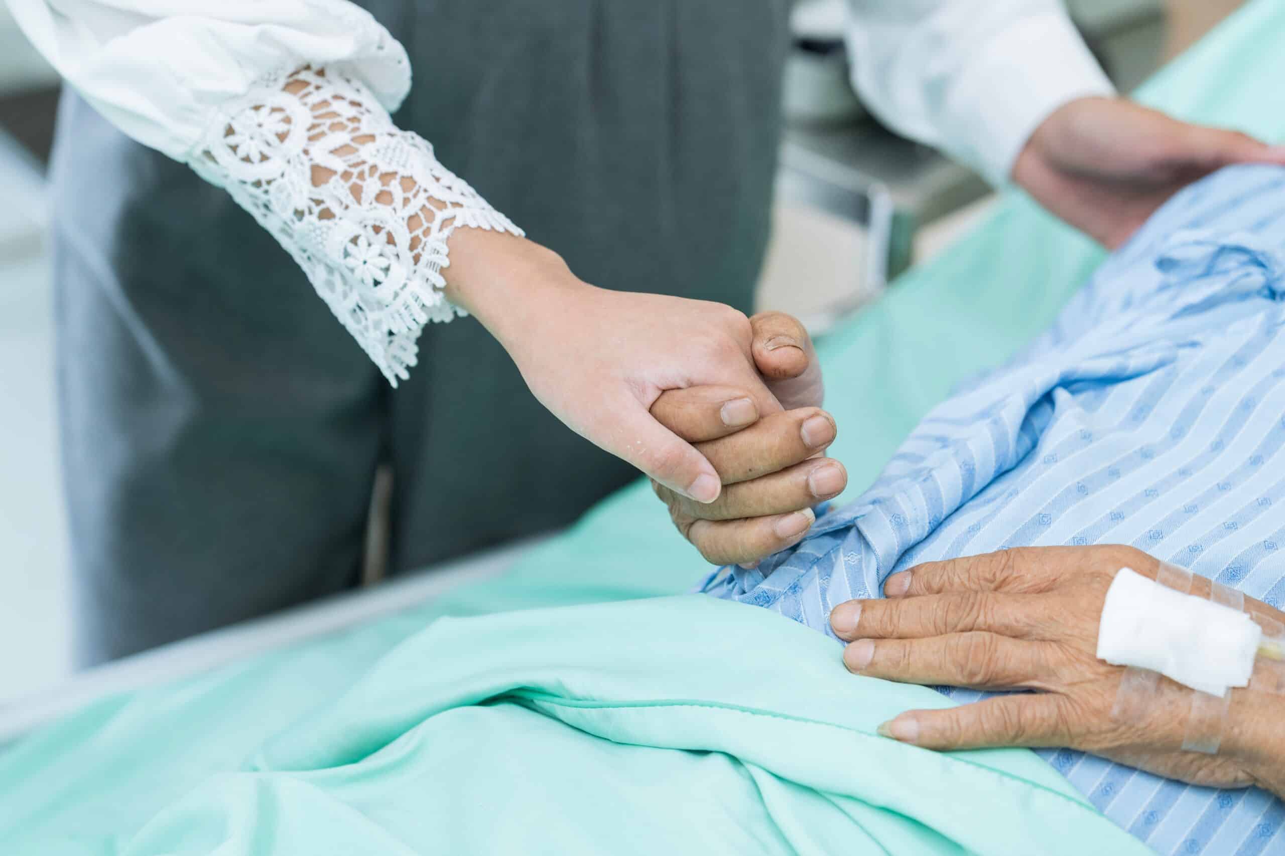 Hand comforting an injured hospital patient whose family consults Pennsylvania personal injury lawyers.