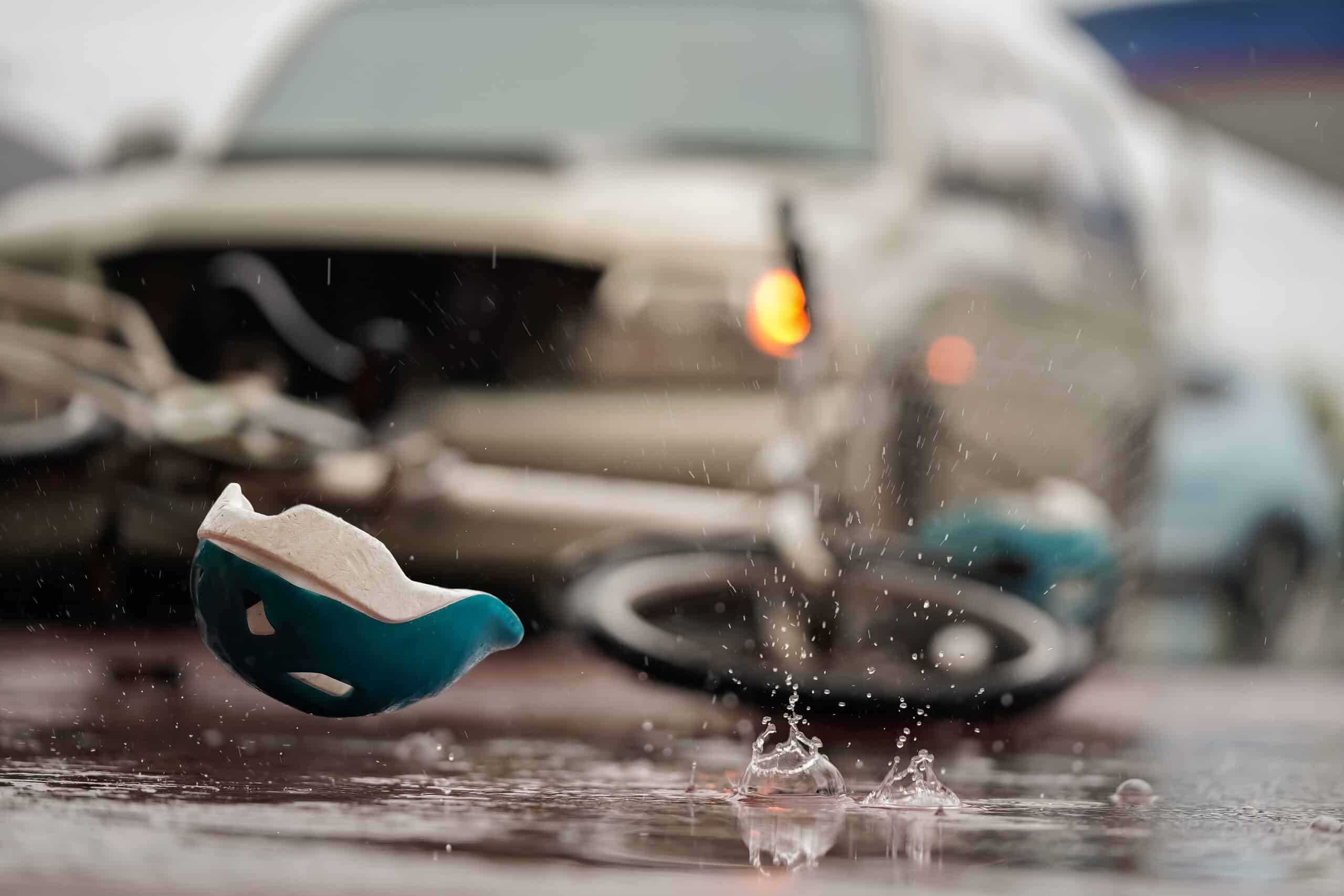 A bicycle helmet lying on the wet road after a crash handled by Philadelphia bicycle accident lawyers.