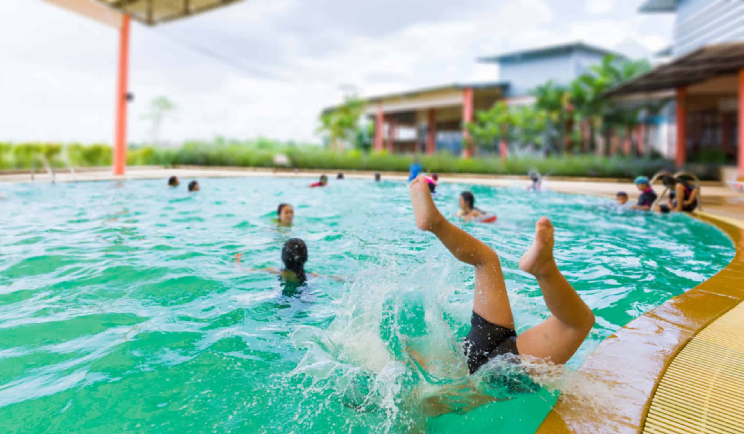 Child splashing upside down in a crowded pool where claims are handled by Philadelphia swimming pool accident lawyers.