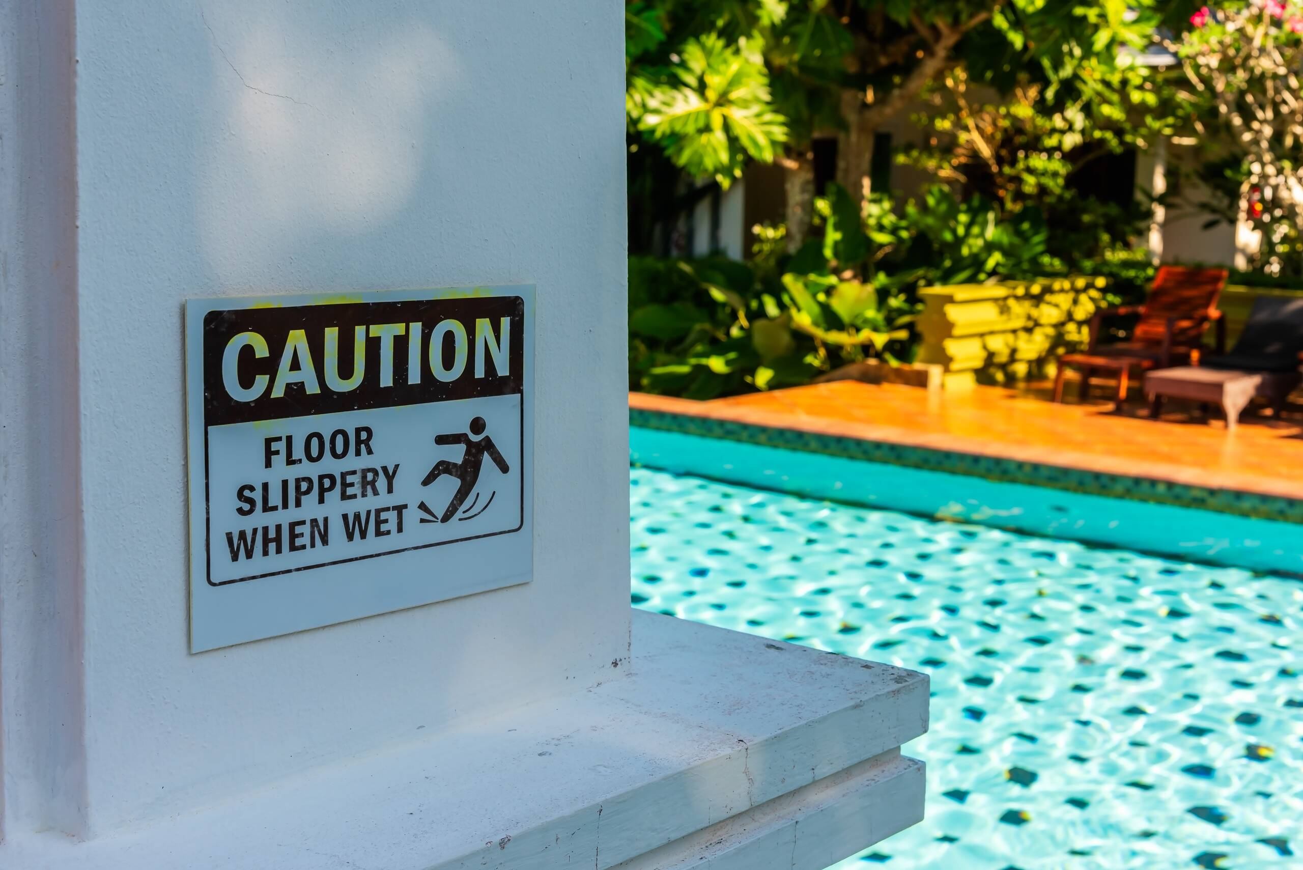Slippery floor warning sign posted near a pool deck handled by Philadelphia swimming pool accident lawyers.