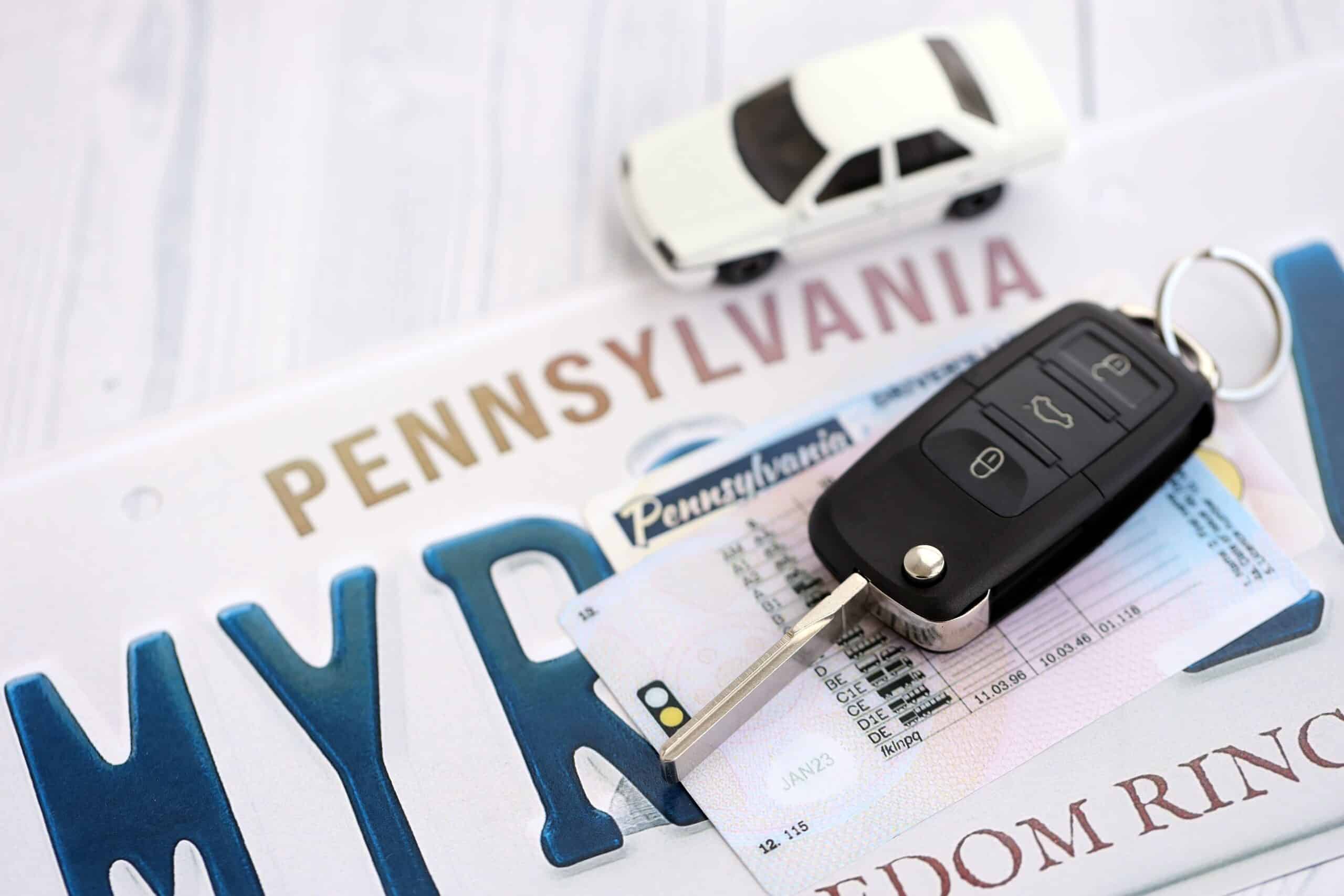 allentown-most-dangerous-roads-for-crashes-1 Car key and a miniature toy car resting on top of a Pennsylvania license plate and driver license.