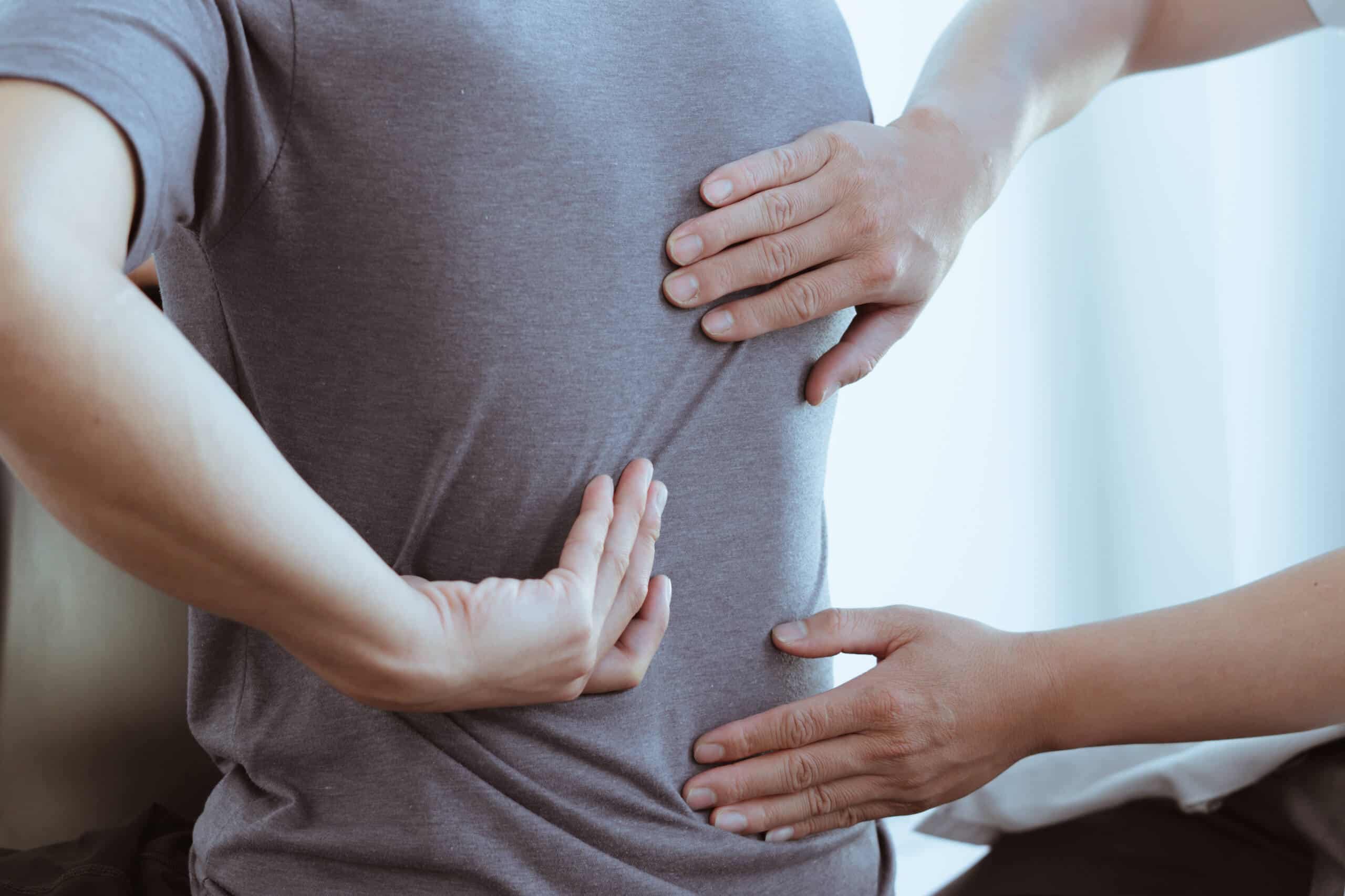 Therapist examining a patient lower back pain representing claims handled by Pennsylvania spinal cord injury lawyers.